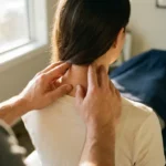Chiropractor die met beide handen de cervicale wervelkolom van een patiënt ondersteunt tijdens een nekbehandeling.